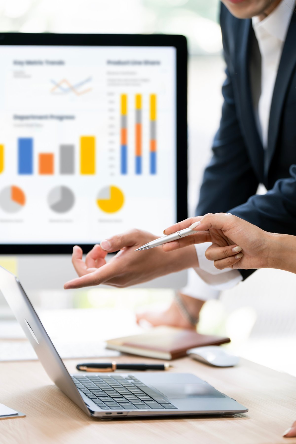 Business partners analysing financial dashboards and growth charts on a laptop